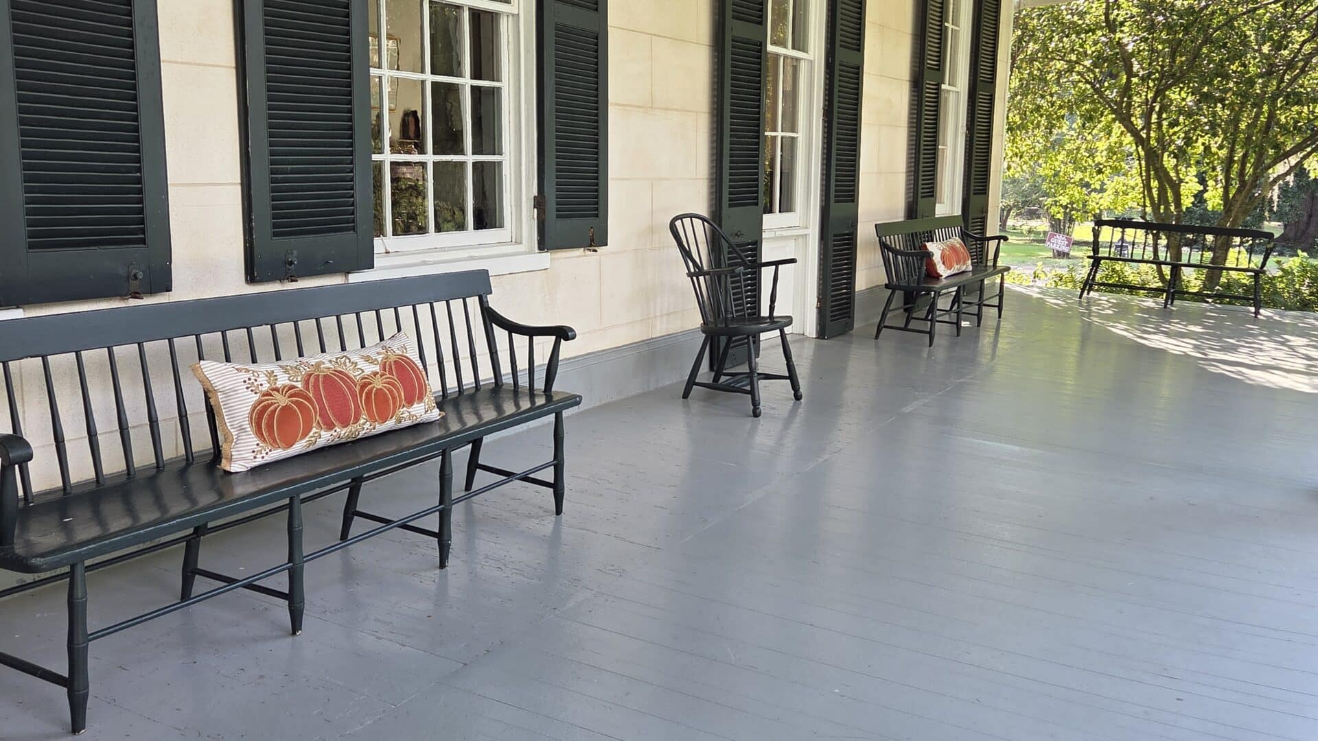 Inviting front porch at Linden Historic Bed & Breakfast decorated with fall-themed pumpkin pillows, perfect for relaxing and enjoying the autumn scenery.