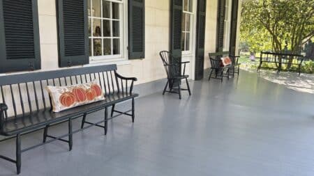 Inviting front porch at Linden Historic Bed & Breakfast decorated with fall-themed pumpkin pillows, perfect for relaxing and enjoying the autumn scenery.